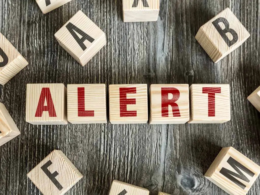 wooden blocks spelling the world alert