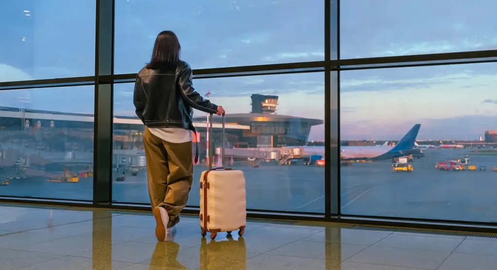 person with suitcase waiting for plane